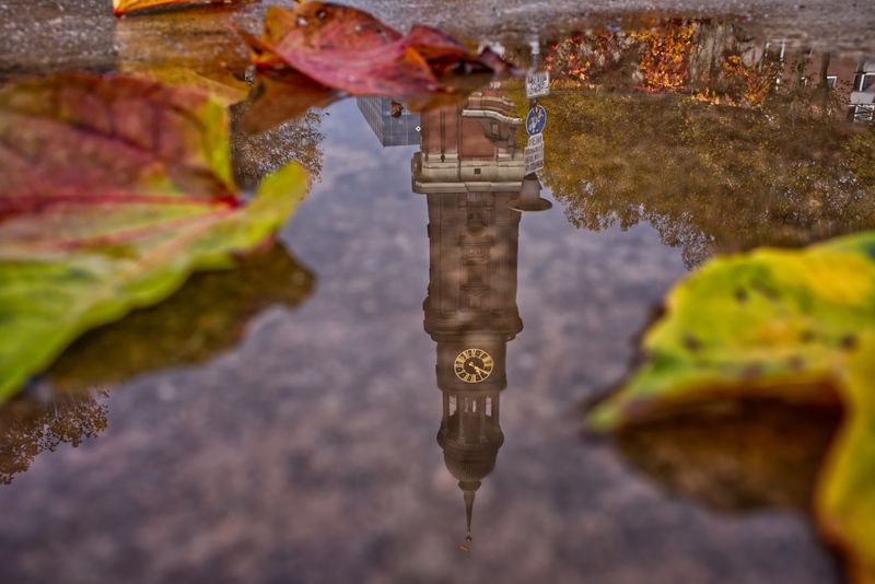 auf dem Bild ist eine Pfütze zusehen, in der sich der Hamburger Michel spiegelt