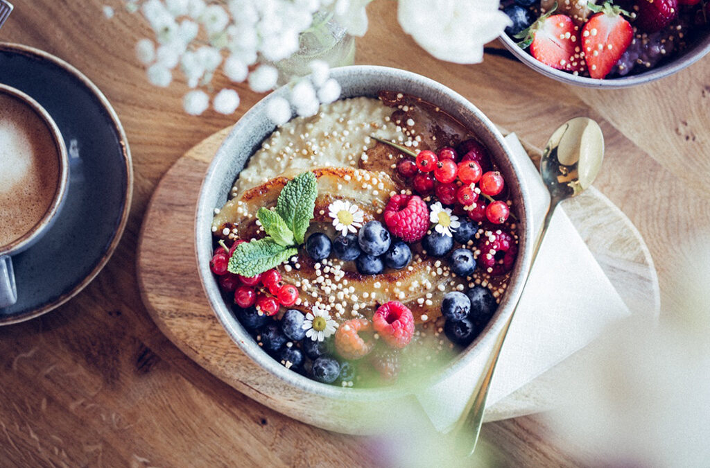 Café in Hamburg: Porridge mit Früchten in Keramikschale auf Holztisch in der SOUL vegan coffee bar