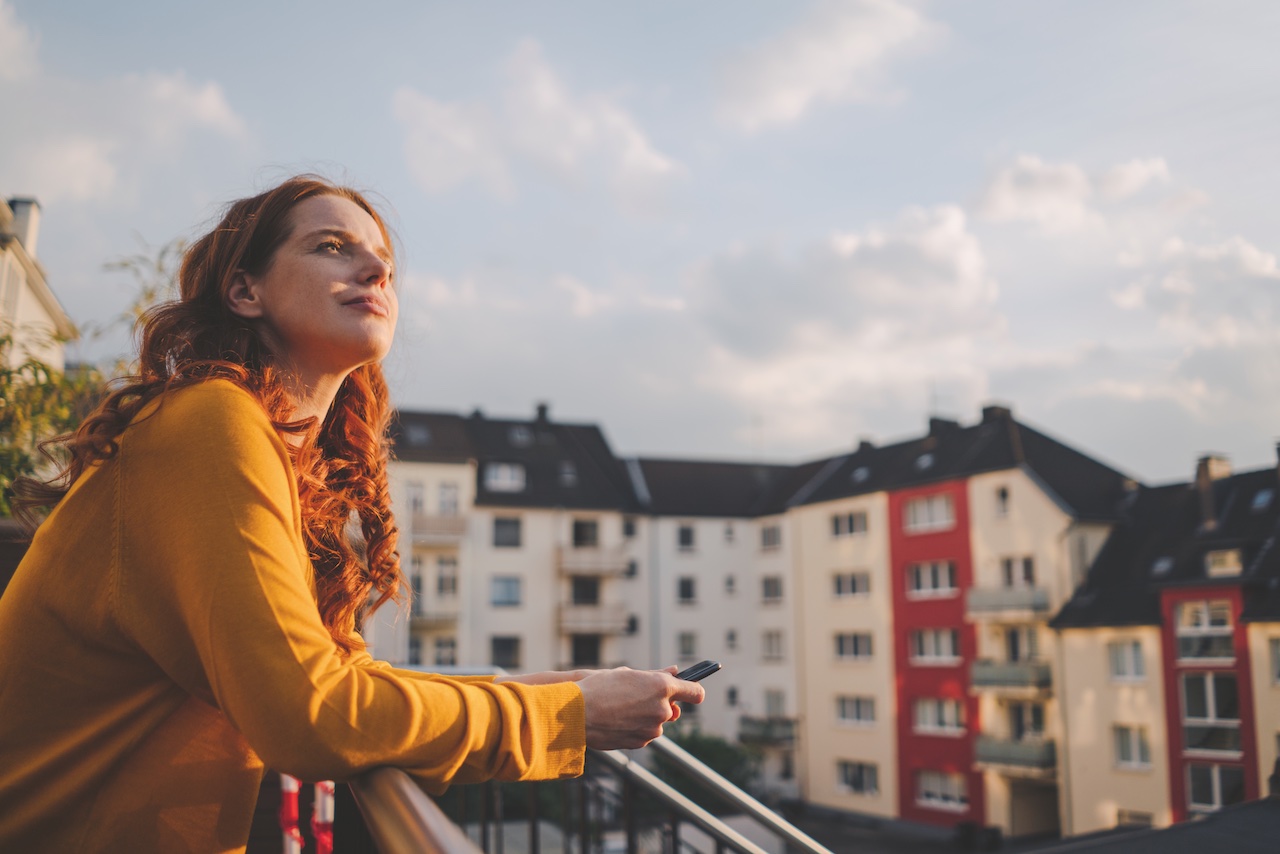 Frau steht auf einem Balkon