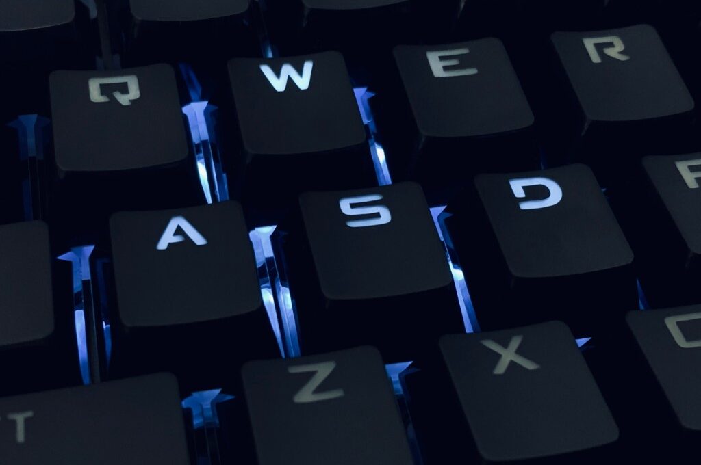 Identitätsdiebstahl: Schwarze Computer-Tastatur in Nahaufnahme mit bläulicher Hintergrundbeleuchtung