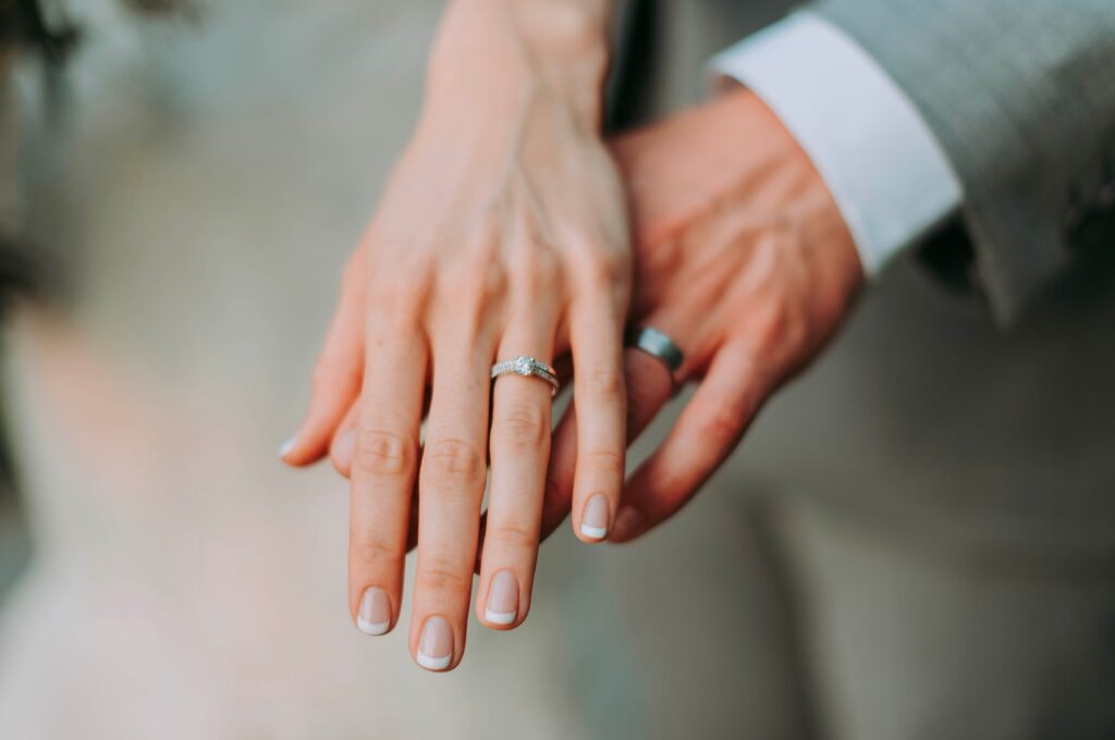 Hochzeit finanzieren, zwei Hände mit Trauringen