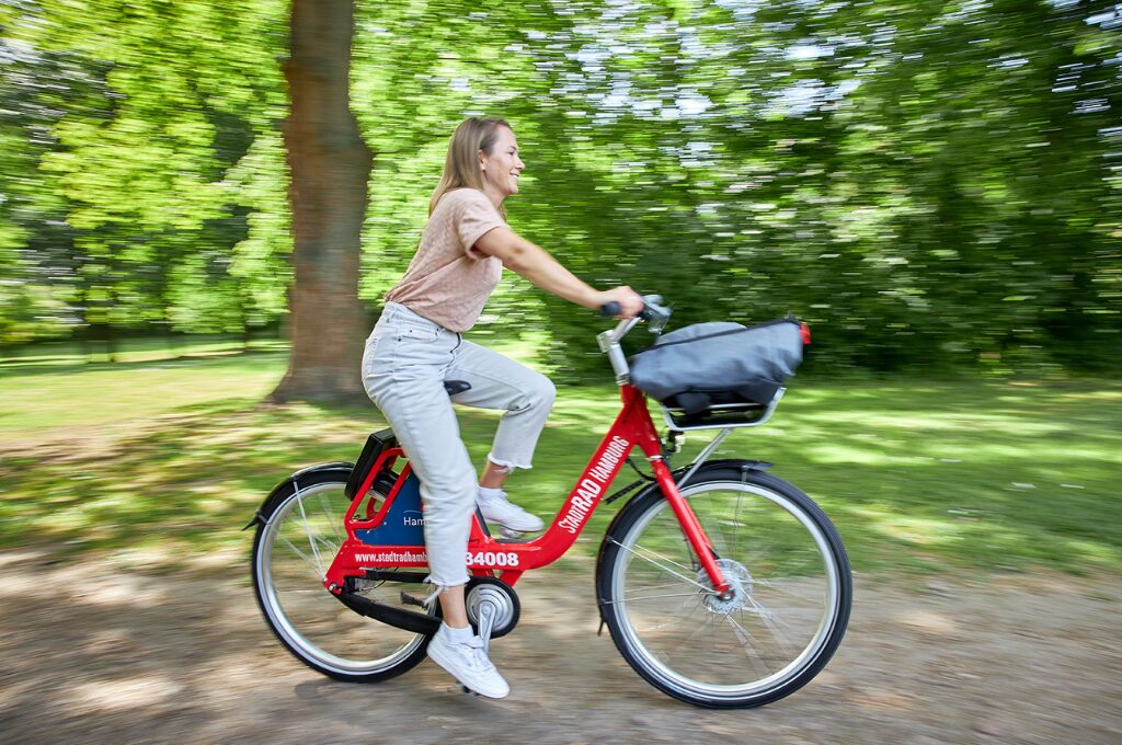 Fahrradverleih in Hamburg: Eine Frau fährt Fahrrad im Park.