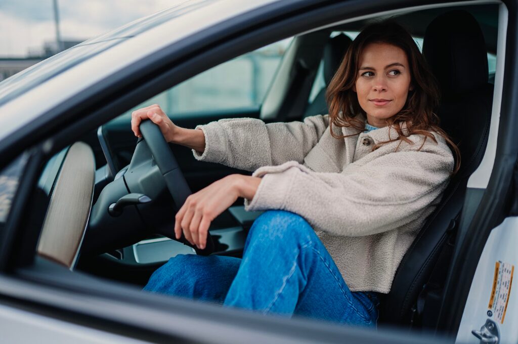 Auto kaufen oder leasen, Frau sitzt im Fahrersitz