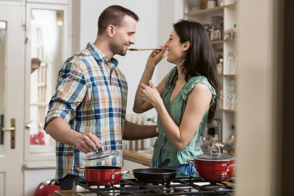 Erste gemeinsame Wohnung, zusammenziehen: Junges Paar kocht zusammen in der Küche