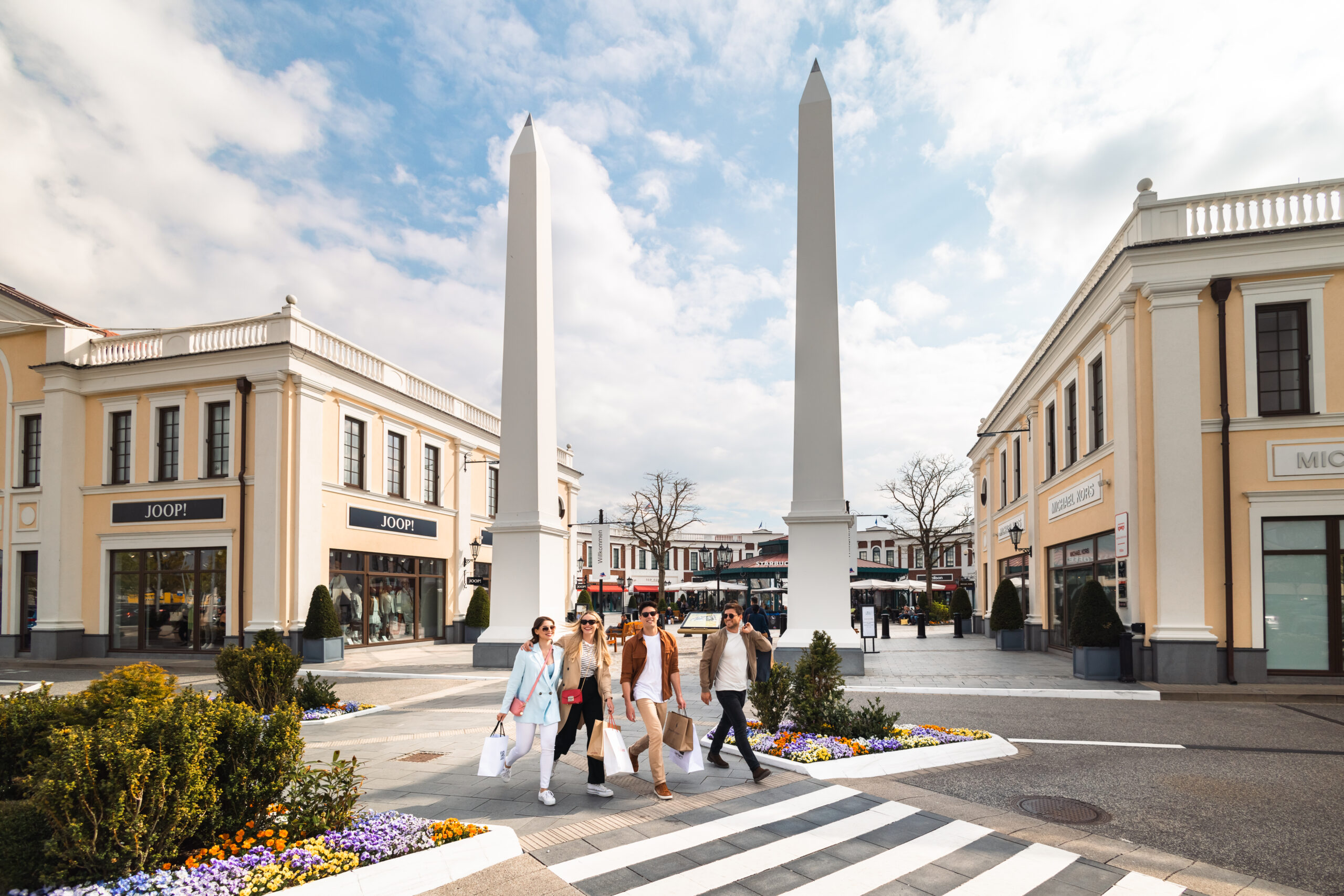 HaspaJoker Highlights im März: Im Designer Outlet Neumünster geht eine Gruppe junger Menschen shoppen