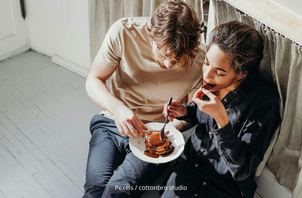 Tagesgeld Teaser, Paar sitzt auf dem Küchenboden und isst Kuchen