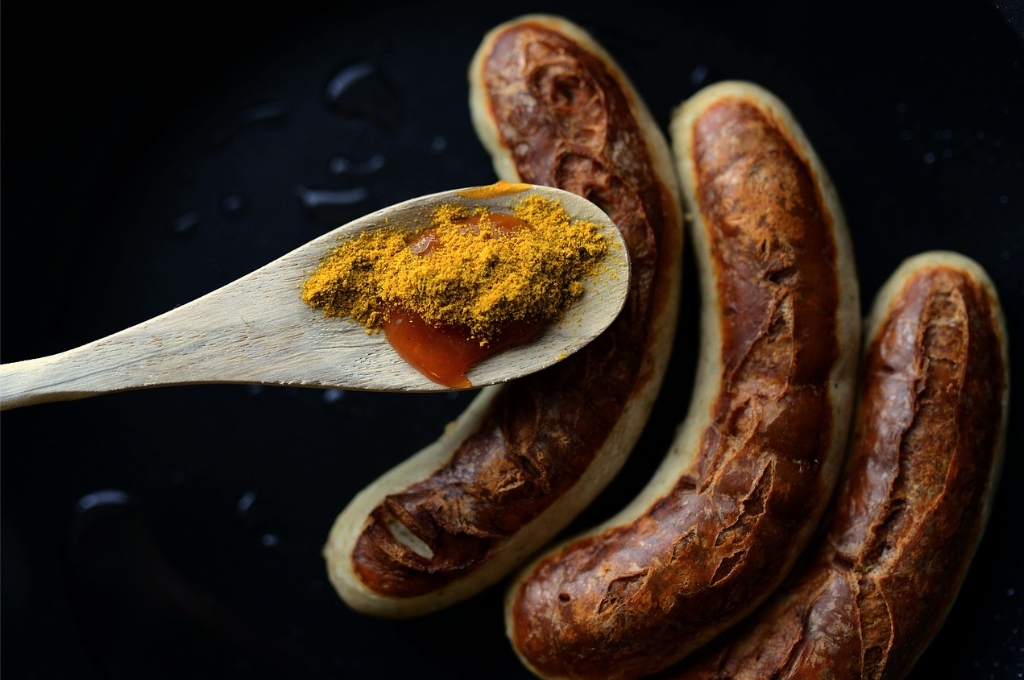 Currywurst in Hamburg: Bratwürste mit einem Löffel Gewürze