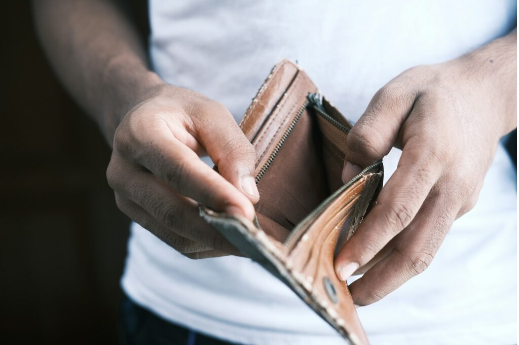 Privatinsolvenz: ein Mann schaut in sein leeres Portemonnaie