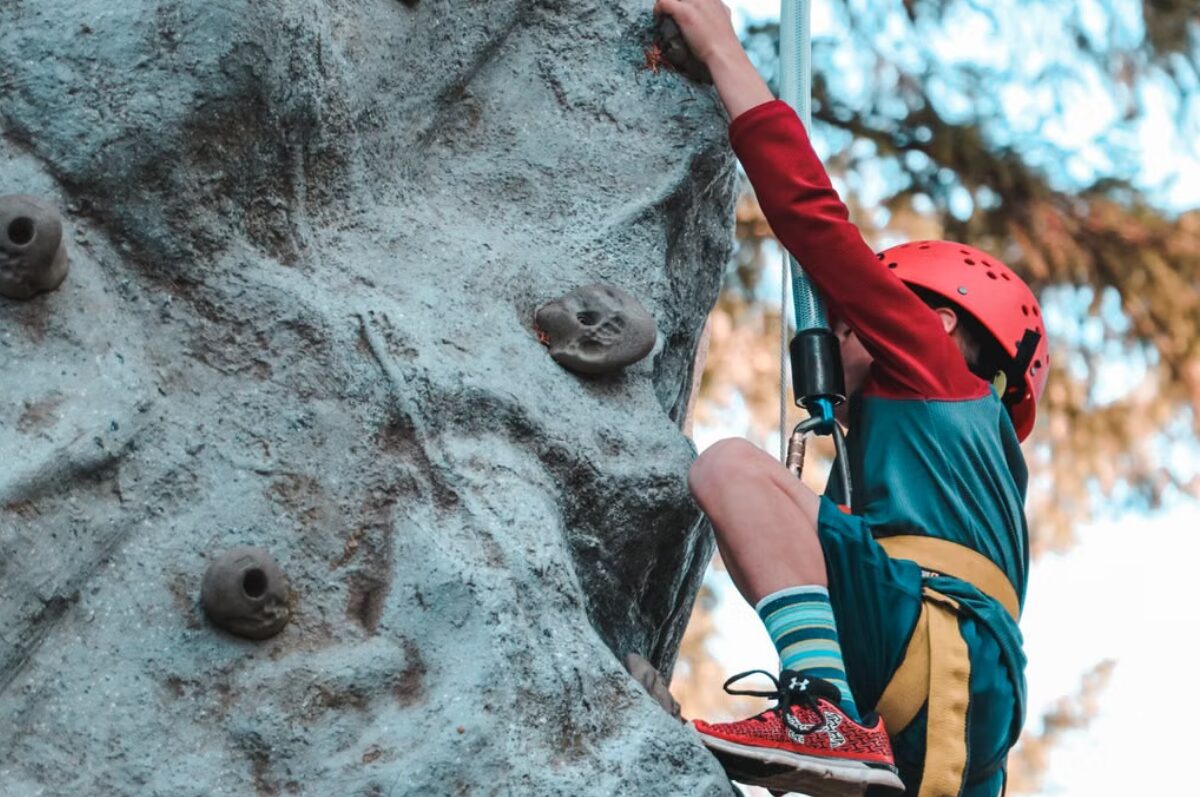 Kletterwald in Hamburg, Kind auf einem Felsen beim Klettern