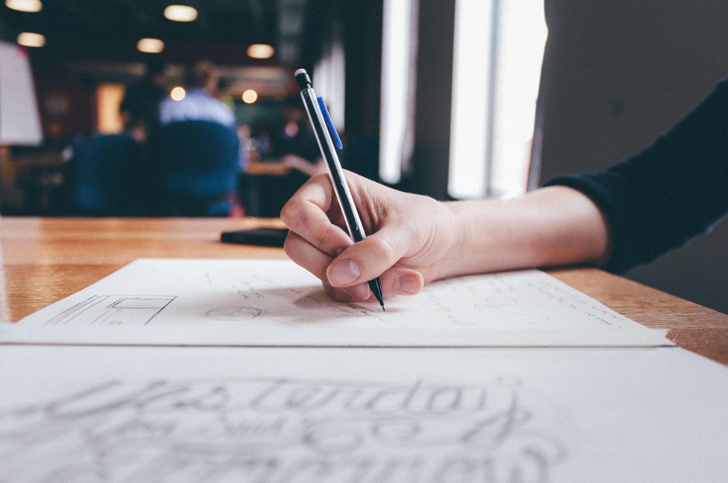 Hand mit Bleistift in der Hand zeichnet