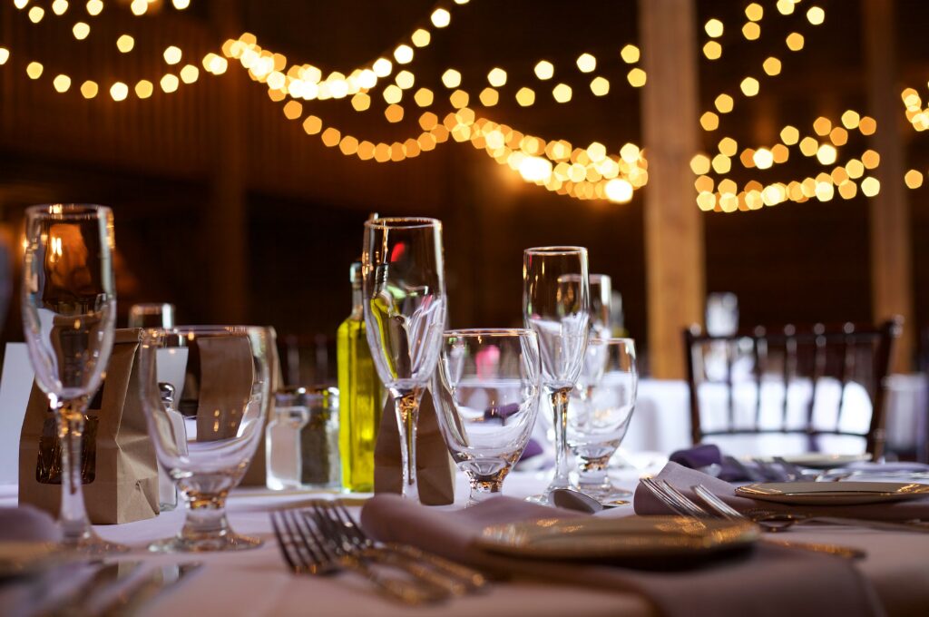 Silvesterpartys in Hamburg, Tischgedeck mit Sektgläsern und bunten Lichtern