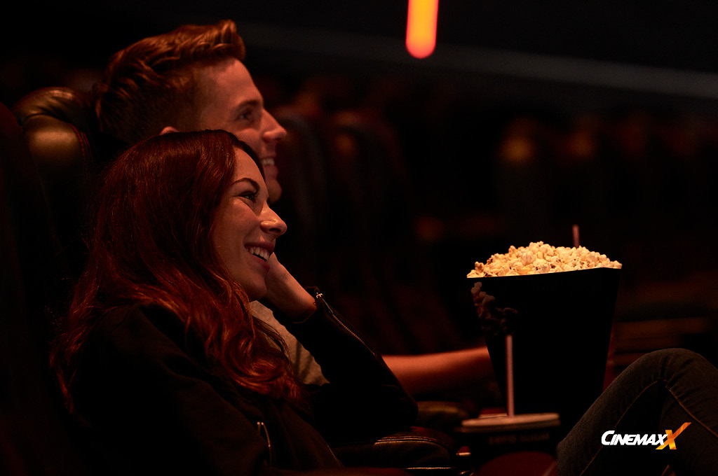HaspaJoker CineMaxx: ein Pärchen sitzt in einem Kinosaal und isst Popcorn