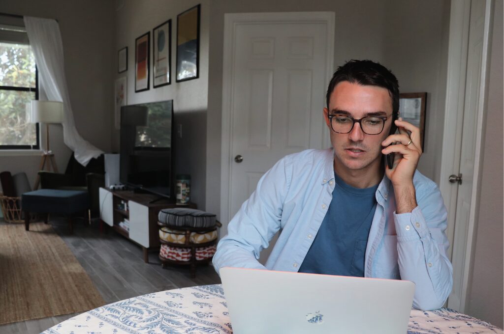 Problem beim Online-Banking, Mann telefoniert vor einem Laptop