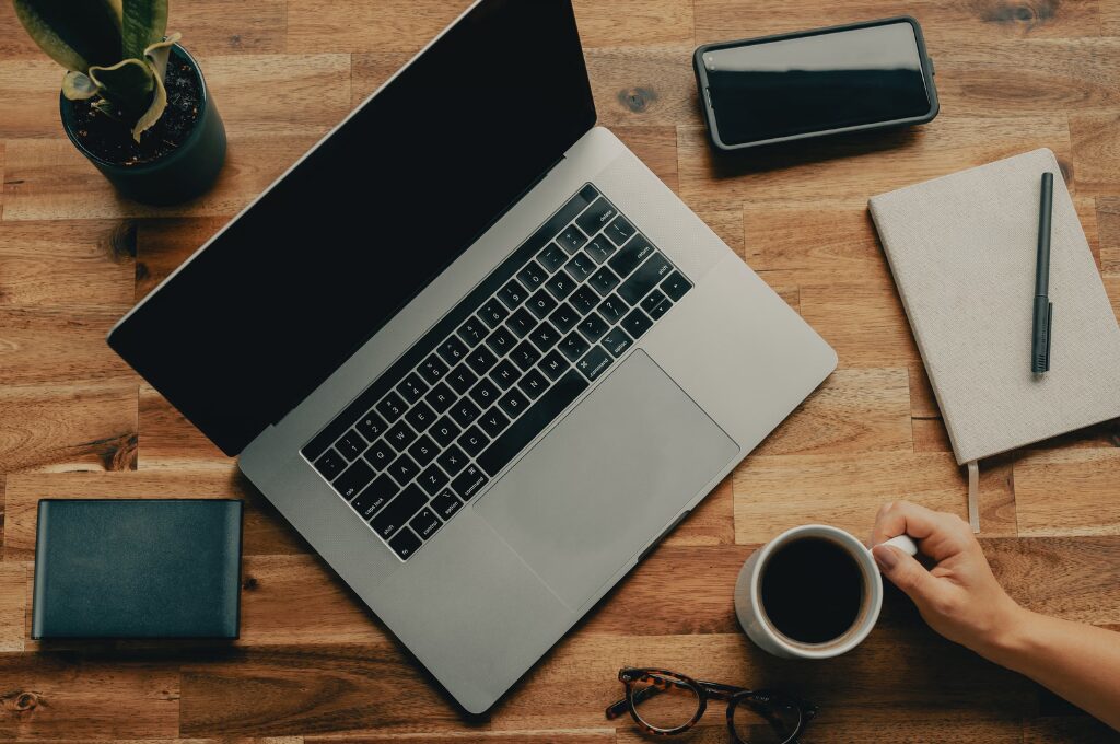 Onine-Banking per App oder Browser, Laptop und Smartphone auf einem Tisch