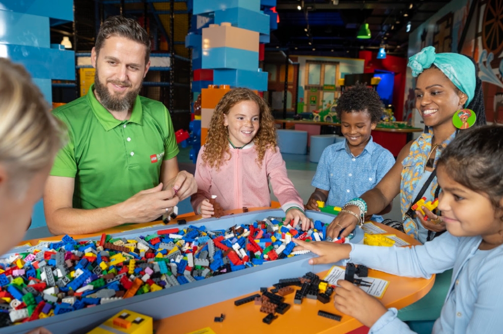 Erwachsene und Kinder spielen mit Klemmbausteinen