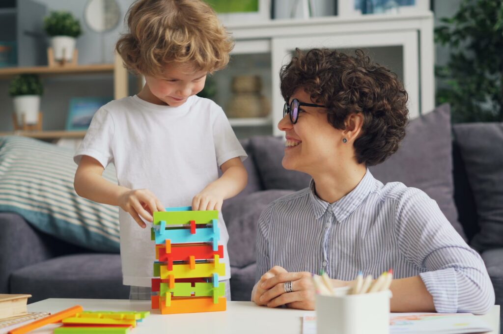 Kinderdepot, Mutter baut mit ihrem Kinder Spielzeug auf