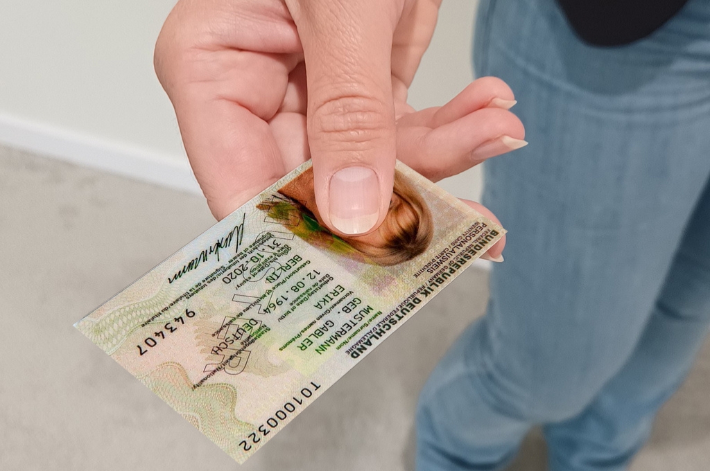 Frau hält Musterausweis in der Hand