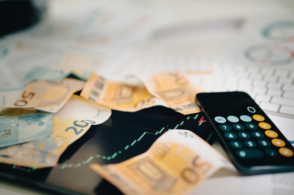 Jahresbudget: Auf einem Tisch liegen geldscheine und ein Taschenrechner