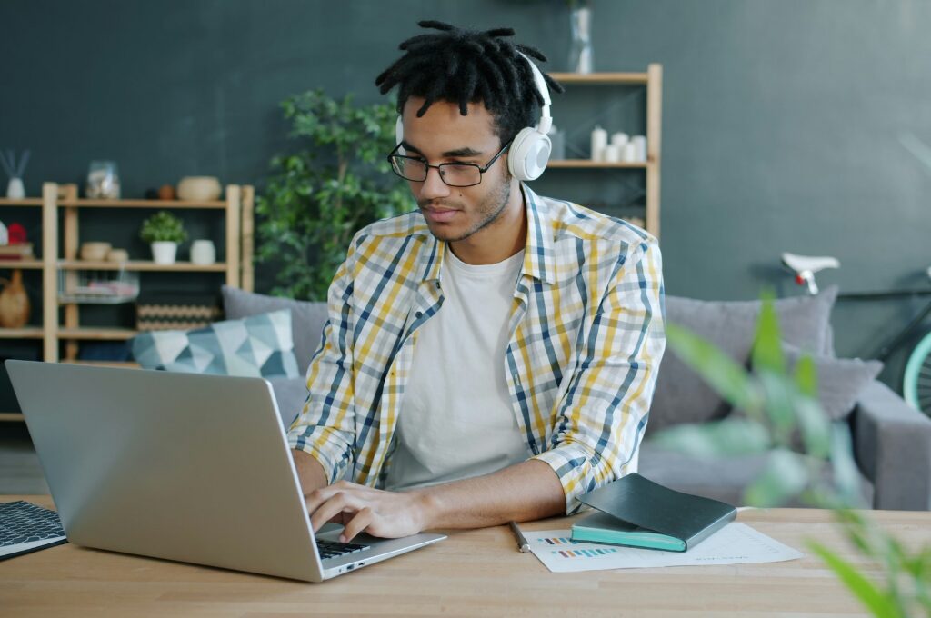 Bankbegriffe, Mann mit Kopfhörer arbeitet am Laptop