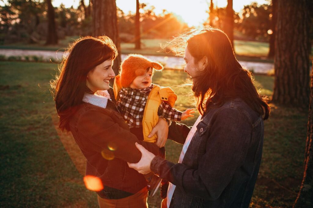Versicherungssprache, dreiköpfige Familie im Park mit Frau, Mann und Baby