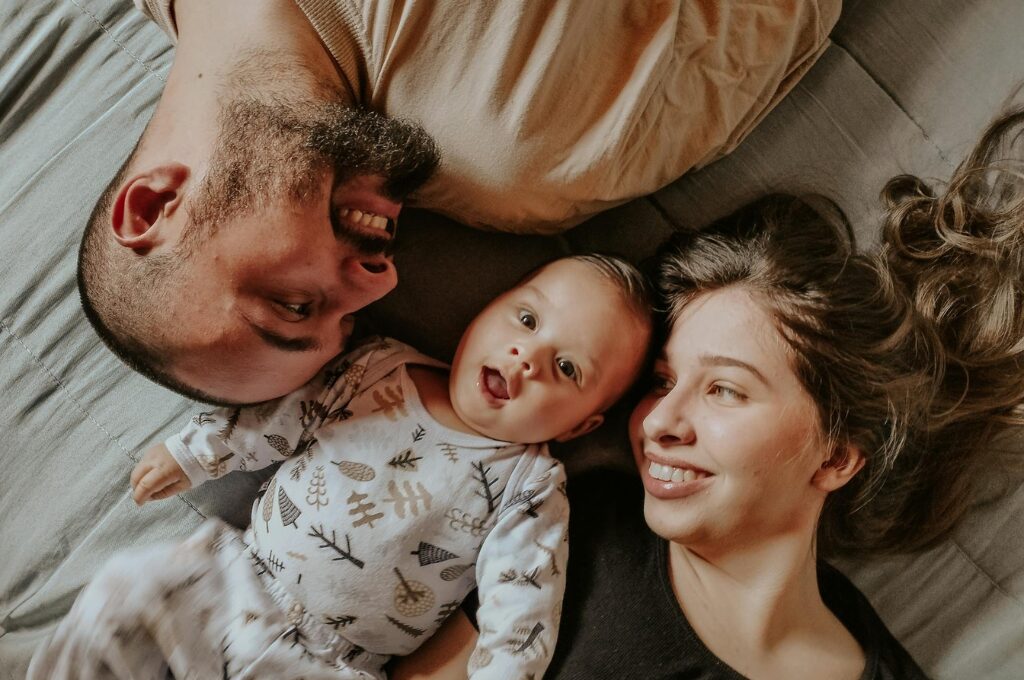 Familienf&ouml;rderung: Eine junge Familie liegt im Bettt