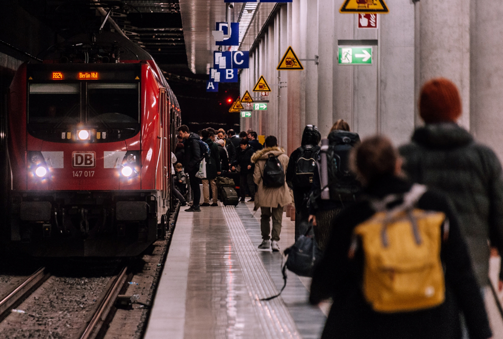 Stranded Traveller Scam, Bahnhofsgleis mit Bahn und Passagieren