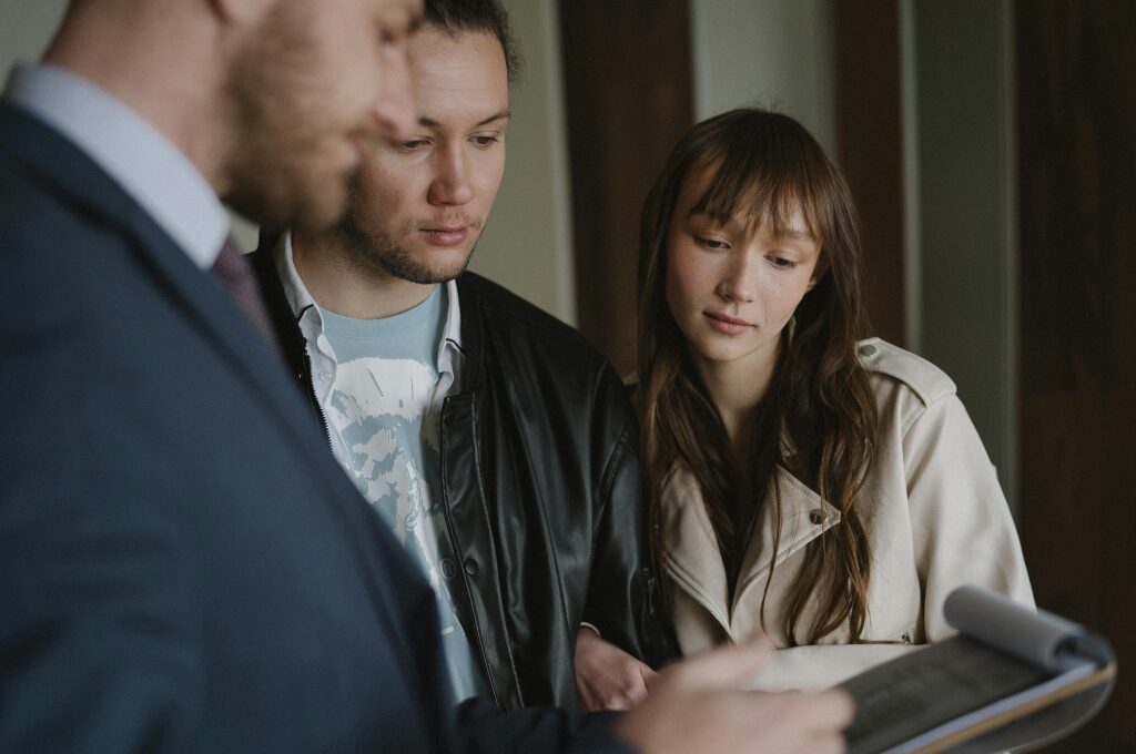 Wohnungsübergabeprotokoll, Paar mit einem Makler schauen auf ein Klemmbrett