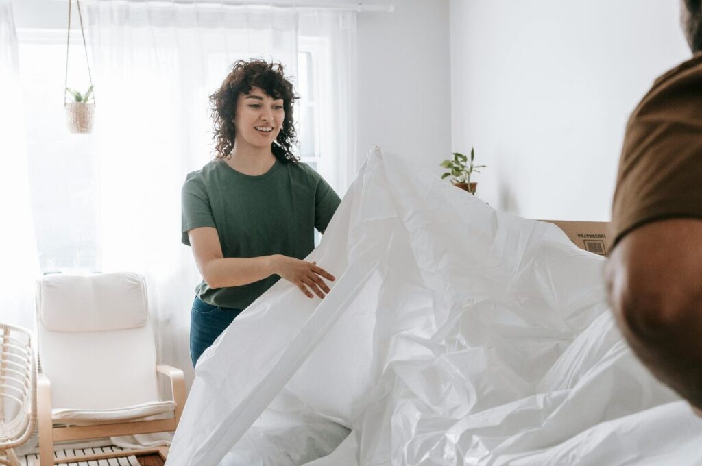 Hausratversicherung, Frau packt Sofa aus