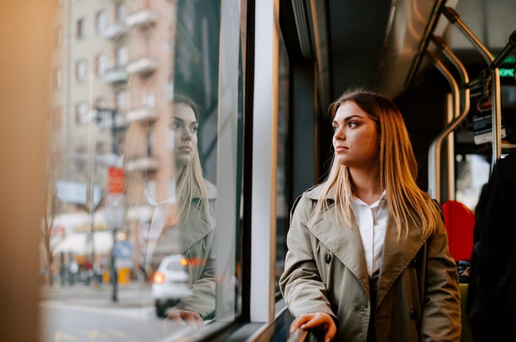 Pendeln nach Hamburg, Frau steht im Bus und schaut aus dem Fenster