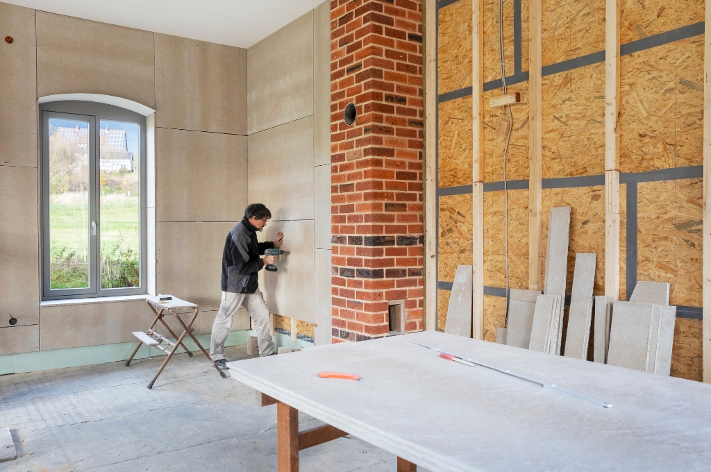 Montage von Gipsfaserplatten vor einer Innendämmung mit Holzfaserplatten und OSB-Platten als Dampfbremse