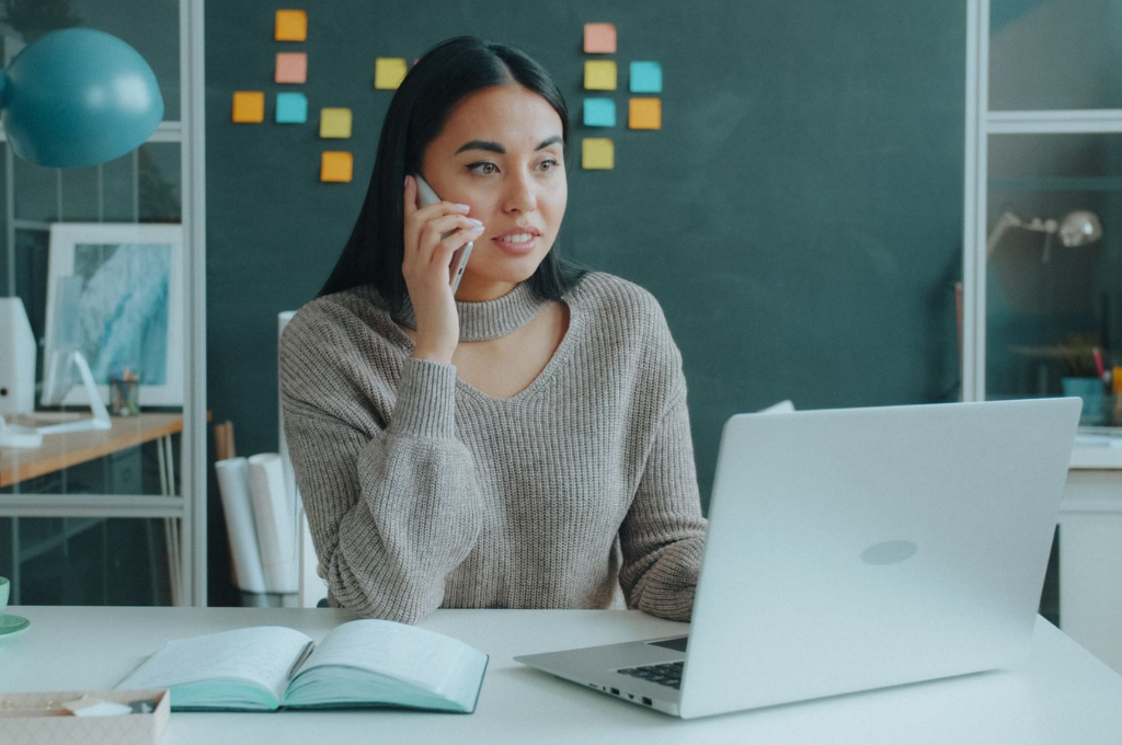 Erster Job Checkliste: Eine junge Frau sitzt am Schreibtisch und telefoniert